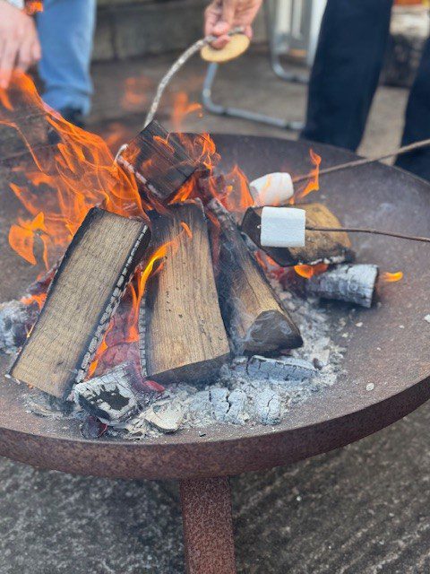 Marshmallows being roasted on sticks over a fire
